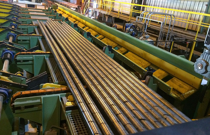 Nickel alloy bars on a mill conveyor line